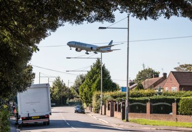 London, Heathrow, United Kingdom - October 3, 2016 American Airlines plane approaching to London Heathrow airport, low above housing estate.