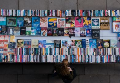 London, UK - October 22, 2016 A woman exploring used and second hand books and record bargains on London Thames Southbank.