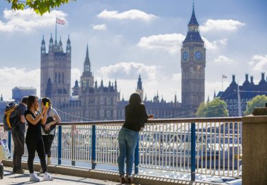 London, UK - September 10, 2015 Tourists talking and making a photos against of Houses of Parliament. View from the Thames embankment. London