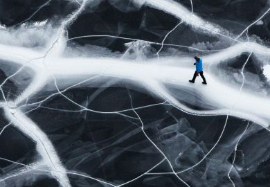 Lone man walking on cracked ice