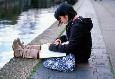 young woman sits by canal
