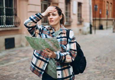 A woman with a map looking lost, sybolising geography department closures