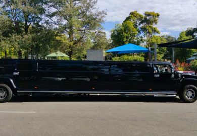 Luxury Stretch Hummer Limousine primarily black in colour, parked outside a community park in South Sydney, NSW Australia