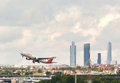 Madrid, Spain; 09-25-2021 Side view of an Airbus A330 aircraft of the Spanish airline Iberia during the take-off maneuve at Madrid Barajas airport with the famous Madrid office tower