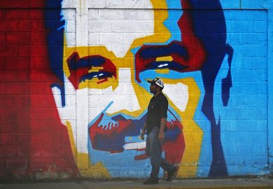 A man walks past a mural depicting Venezuelan President Nicolas Maduro in Caracas on January 3, 2026.