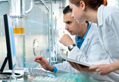 Male and female scientists at work in laboratory