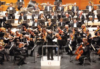 Male conductor conducting orchestral concert