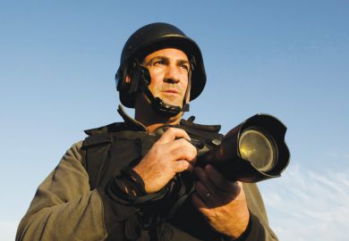 Male war photographer wearing protective helmet and vest