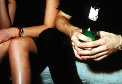 Man and woman seated, drinking alcohol