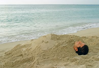 Man buried in sand on beach
