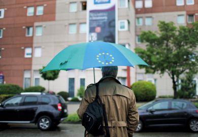 Man carrying a European Union (EU)-branded umbrella