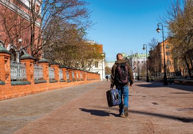 Moscow, Russia. A man carries a suitcase in the street. To illustrate an exiled Russian scholar.
