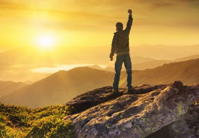Man celebrating climb to mountain peak