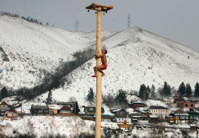 Man climbing wooden column, Krasnoyarsk, Siberia Man climbing wooden column, Krasnoyarsk, Siberia