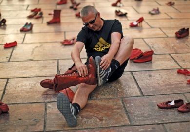 Man compares shoes, La Constitucion Square, Malaga, Spain Man compares shoes, La Constitucion Square, Malaga, Spain