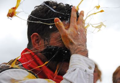 Man cracking egg on forehead