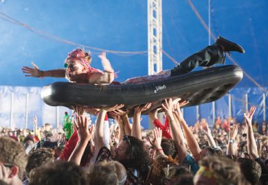 Man crowd surfing on inflatable bed, Bestival 2015, Isle of Wight