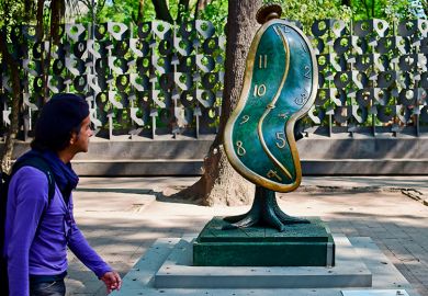 A man looks at the "Dance of Time I" sculpture by Spanish artist Salvador Dali. To illustrate that funding provided for PhD researchers is often not enough to cover the completion of a doctorate.