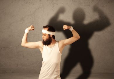 Man flexing muscles with shadow on wall Man flexing muscles with shadow on wall