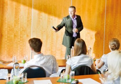 Man handing microphone to audience member Man handing microphone to audience member