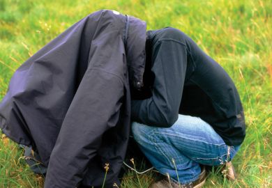 Man with head under his coat