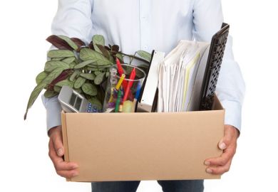 Man holding a box filled with work-related items Man holding a box filled with work-related items