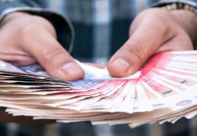 Man holding fan of British fifty pound notes