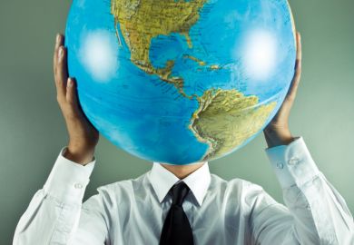 Man holding globe in front of face
