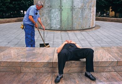 Man lays down while another works behind Man lays down while another works behind