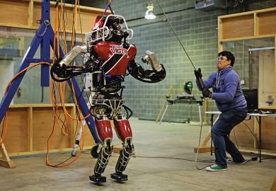 Man lifting robot for testing in preparation for the Defense Advanced Research Projects Agency (DARPA) robotic challenge