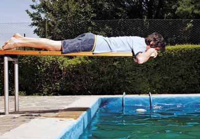 Man on diving board over swimming pool