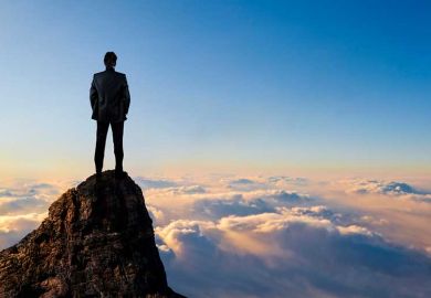 Man on top of mountain above clouds