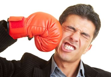 Man punching himself in face with boxing glove