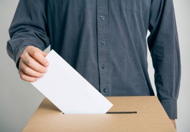 Man putting vote in ballot box Man putting vote in ballot box