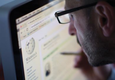 Man reading Wikipedia page on desktop computer (PC)