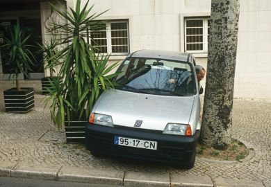 Man reverses his car into a narrow space