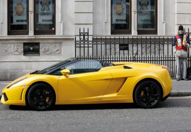 Man selling Big Issue next to Lamborghini, Covent Garden, London