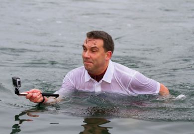 Man standing in water taking selfie photograph Man standing in water taking selfie photograph