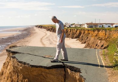 Man standing on the edge of an eroded cliff Man standing on the edge of an eroded cliff