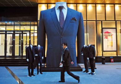 Man walks past huge suit, Shenyang, Liaoning province