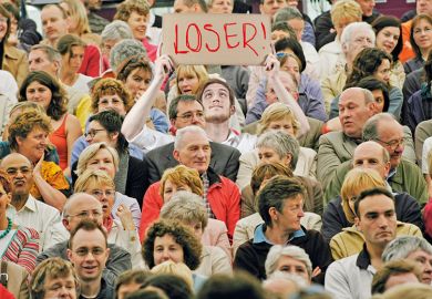 Man with loser sign in crowd