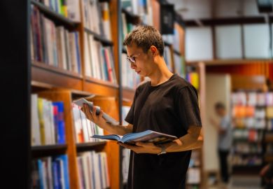  man chooses suitable books while reading in the library