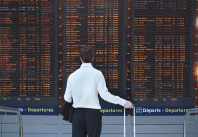 Man looking at airport departure board