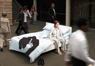 A man in pyjamas in a bed in the street