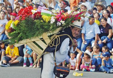 A man with a lot of flowers on his back