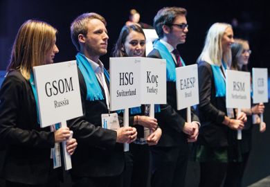 Master's degree students holding university name paddles Master's degree students holding university name paddles