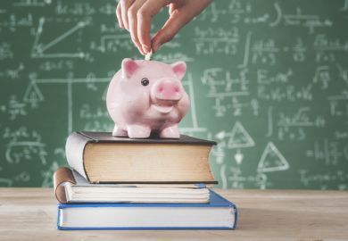 A piggy bank in front of a blackboard covered in formulas, symbolising maths funding
