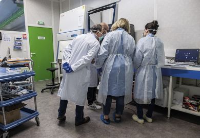 Laboratory technicians and biologists discuss testing procedures as they operate a ribonucleic acid extractor at the LBM LxBio medical biology laboratory in Rodez, France