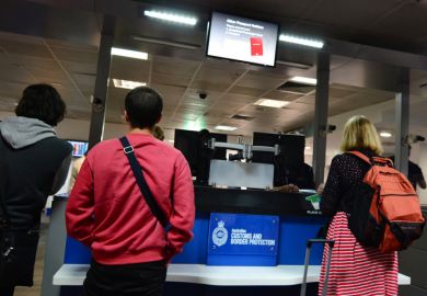 Melbourne, Australia - April 10, 2014 Passengers stand at an Australian Customs and Border Protection checkpoint in Melbourne airport. The agency responsible for the safety, security and commercial interests of Australians