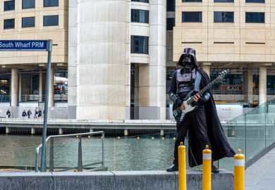 Melbourne, Australia - December 14, 2019 Street artist dressed as Darth Vader playing electric guitar